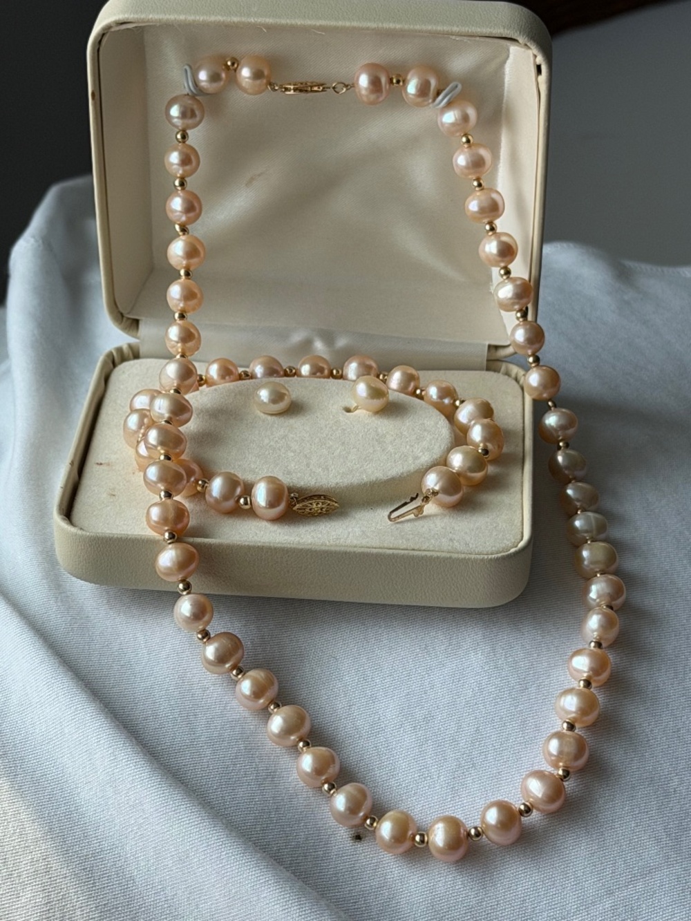 Elegant light peach pearl and gold necklace.
